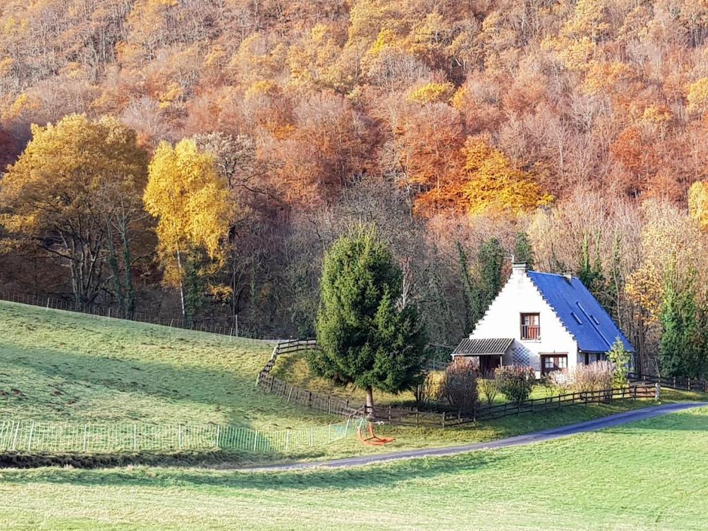 a small white house in a field next to a forest at Gite Au pied du Pic du Midi in Campan