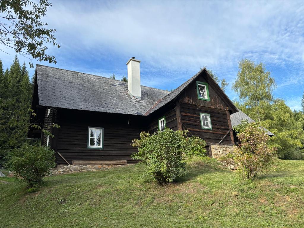a large wooden house on a grassy hill at Lorenzfranzl in Sankt Oswald ob Eibiswald