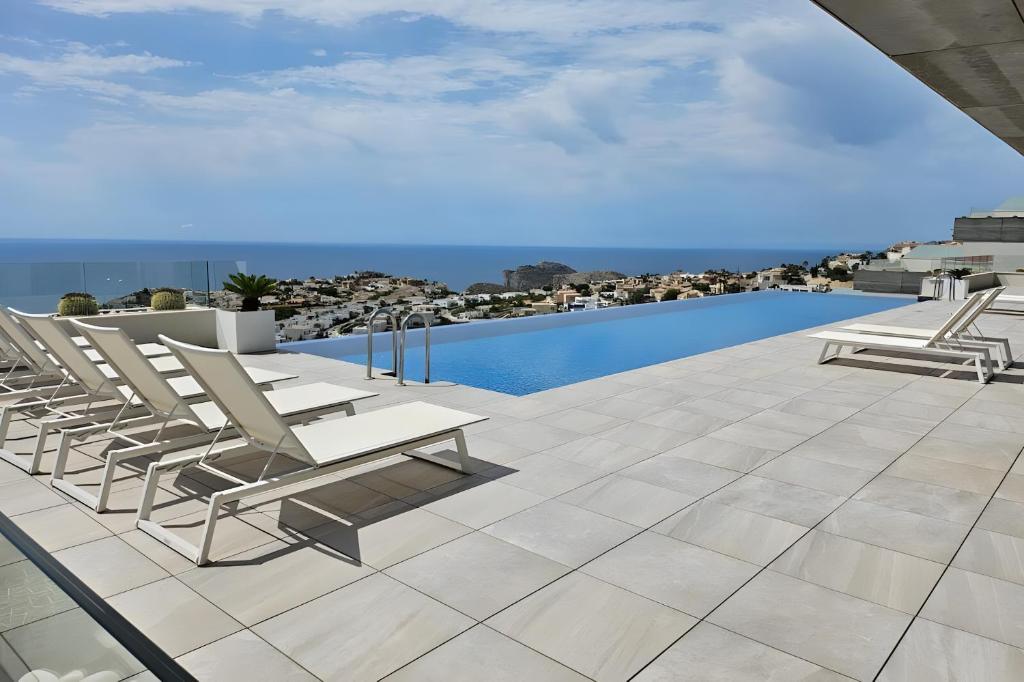 a patio with lounge chairs and a swimming pool at Blue infinity 7 in Cumbre del Sol