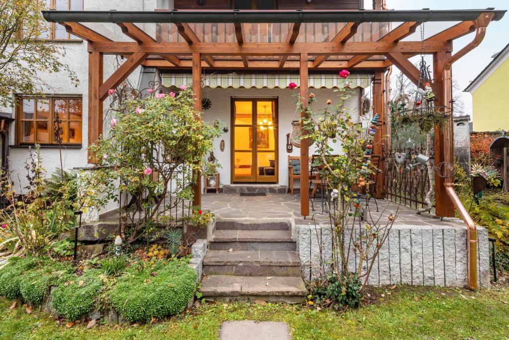a house with a wooden pergola and stairs to the door at Vroni Ferienwohnung - Hochzoll in Augsburg