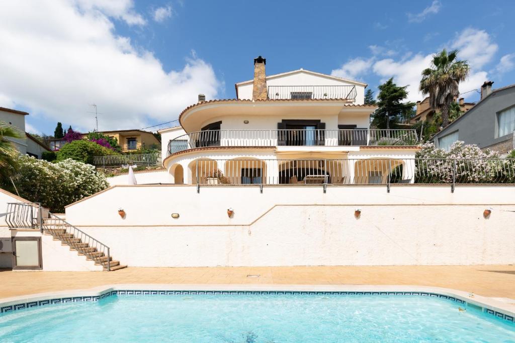 a house with a swimming pool in front of a house at Casa Vista Del Mar in Calonge