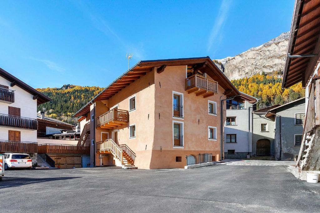 a building with a parking lot next to a mountain at Appartamento Via Livigno in Isolaccia