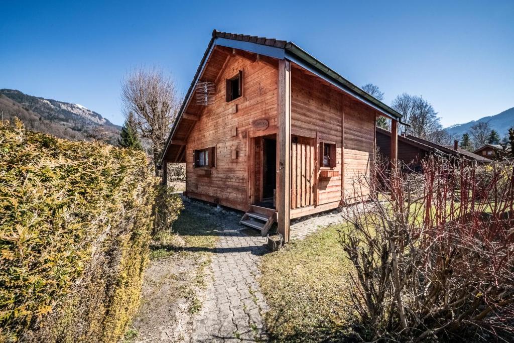 an old wooden building with a door in a field at Chalet 6p Simple - Patchy in Verchaix