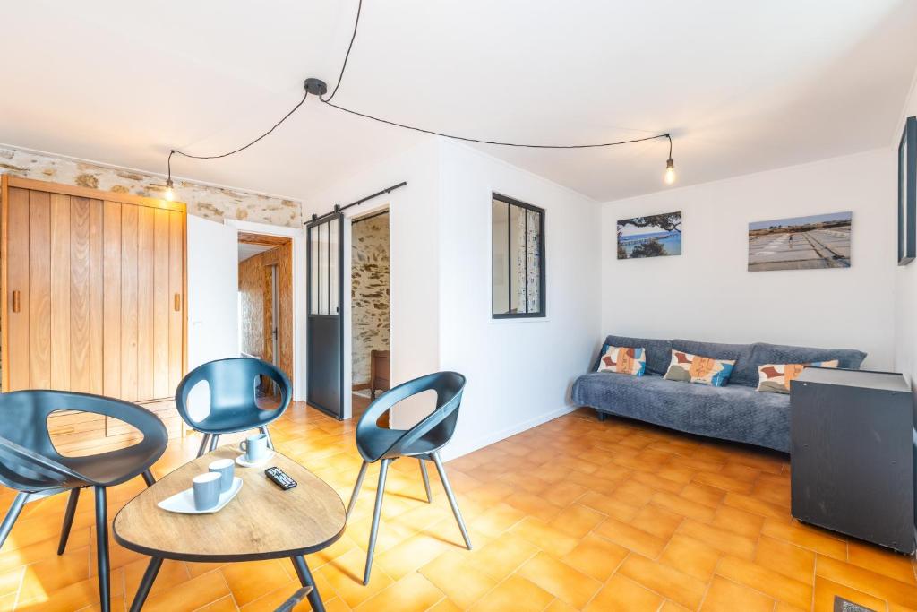 a living room with a blue couch and chairs at Maison traditionnelle au centre in Les Sables-d'Olonne