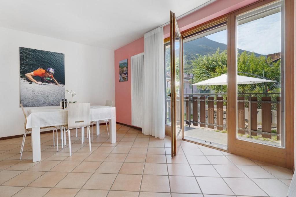 a dining room with a table and a balcony at Katzemburg 5 Plus in Arco