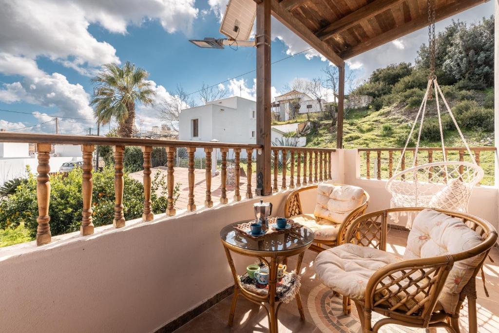 a patio with chairs and a table on a balcony at Traditional Thea Home Vati Rhodes in Vátion