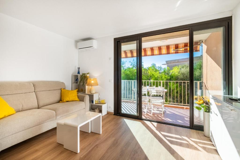a living room with a couch and a balcony at Mon Repaire à Frejus - proche plage in Fréjus