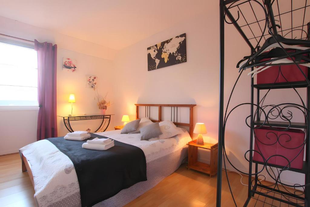 a bedroom with a bed with two towels on it at Côte fleurie -Le Cottage D'honfleur in Honfleur