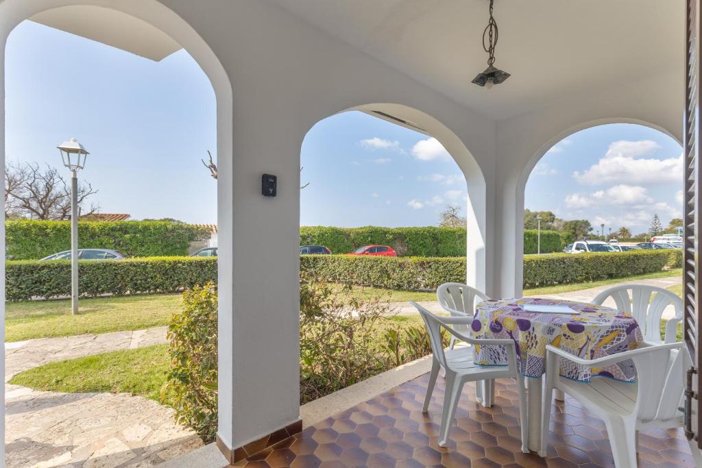a dining room with a table and chairs on a porch at Giuliana Apartment in Alaior