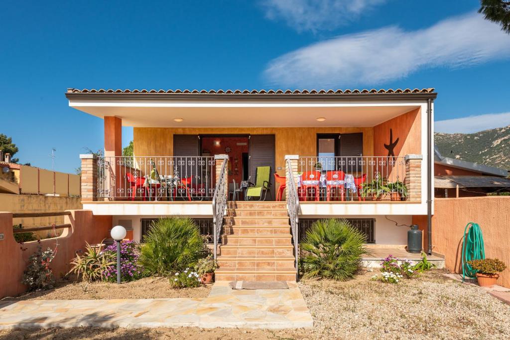 a house with a staircase leading to a balcony at Villetta Delfino in Sìnnai