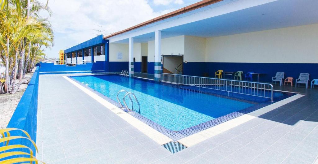 a large swimming pool next to a building at Sun Inns Setiawan in Sitiawan