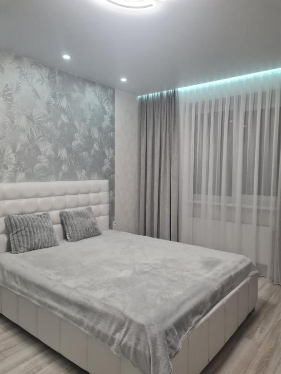 a bedroom with a large bed with a painting on the wall at Апартаменти Центр in Lutsk