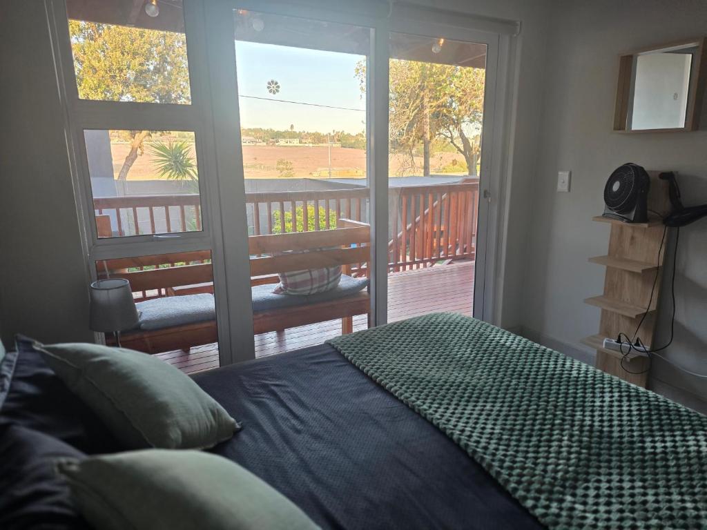 a bedroom with a bed in front of a balcony at 35 Amanda - Durbanville in Cape Town