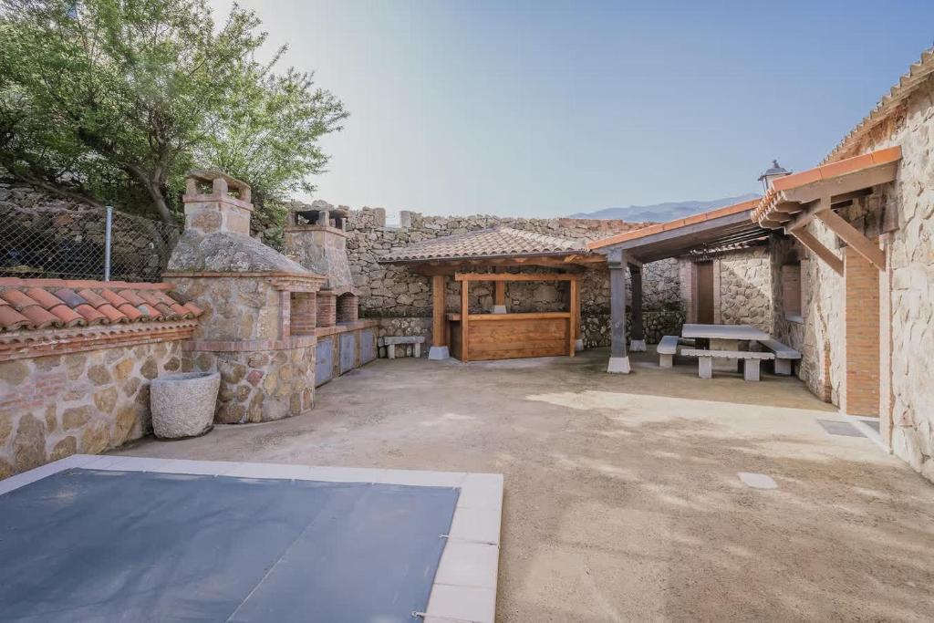 an outdoor patio with a picnic table and a building at El Cauce in Navaluenga