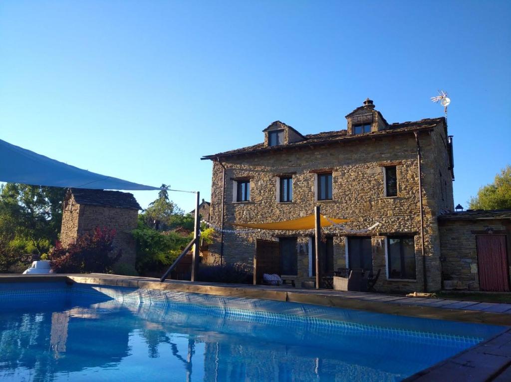 a house and a swimming pool in front of a building at A Boira Rural in Osia