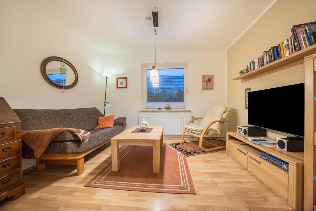 a living room with a couch and a tv at Gästeapartment Hannover in Hannover