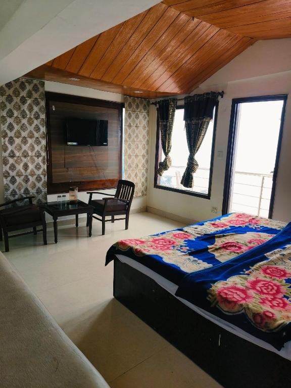 a bedroom with a bed and a living room at The Plaza Dalhousie - Near Ghandhi Chowk Mall Road in Dalhousie