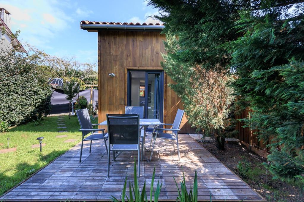 a patio with a table and chairs in a backyard at Loc Ty Home in Soustons