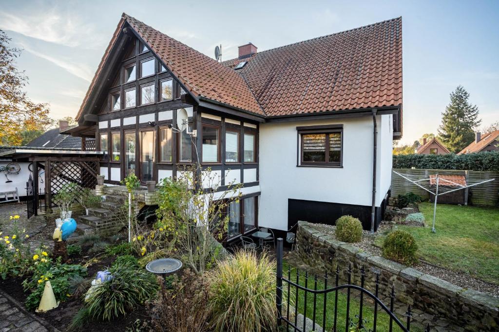 a white and black house with a garden at Ferienwohnung über 2 Etagen in Trollenhagen