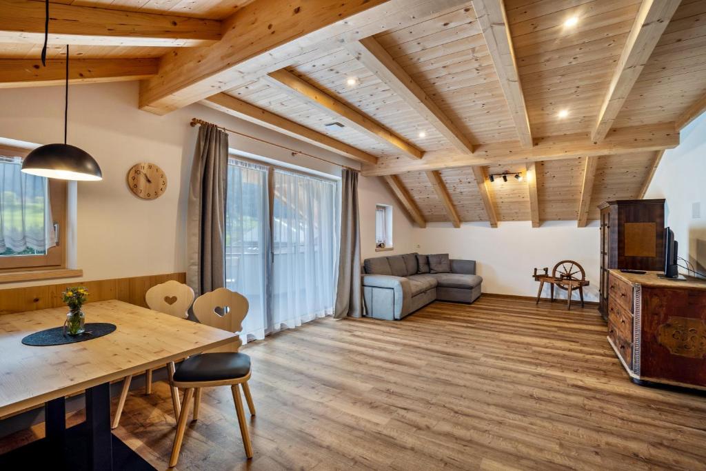 a living room with wooden ceilings and a table at Krämerhof Apt Aferer Geisler in Rodengo