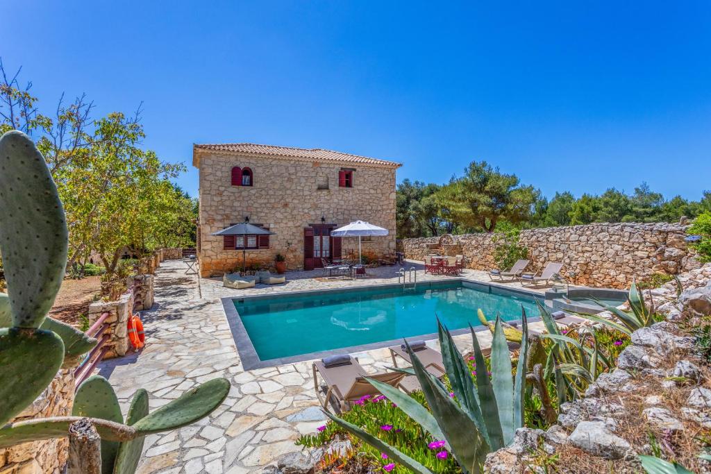 an external view of a villa with a swimming pool at Villa Ira in Agios Leon