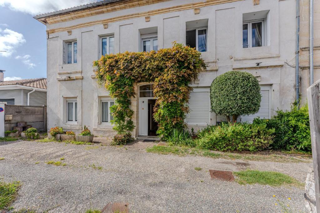 an old house with vines growing on the side of it at Appartement de maitre traversant in La Teste-de-Buch