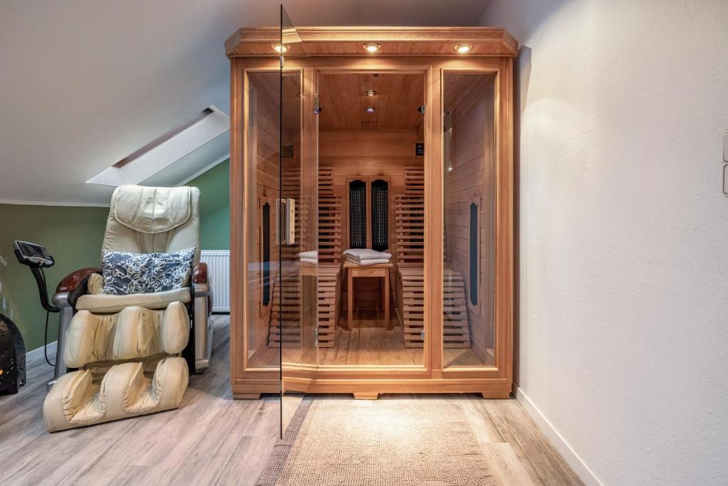 a glass elevator in a room with a chair at Ferienwohnung Solling-Lounge in Holzminden