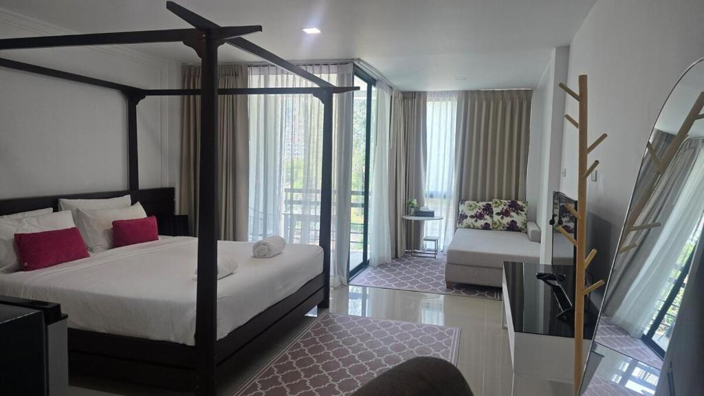 a bedroom with a canopy bed and a couch at joyful the Kris406 in Ban Lum Fuang