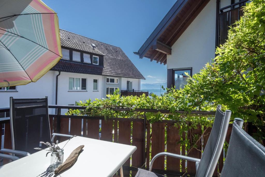a bird sitting on a table with an umbrella on a balcony at Gästehaus Heinemann - Og5 in Langenargen