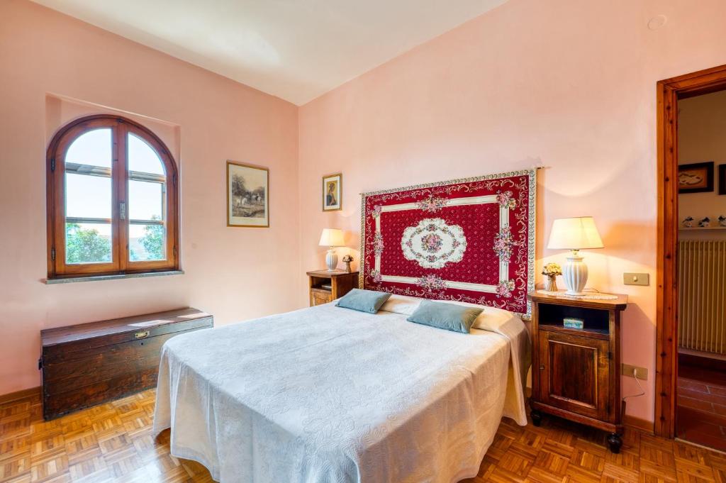 a bedroom with a large bed with a red headboard at Villa Marta in Spoleto