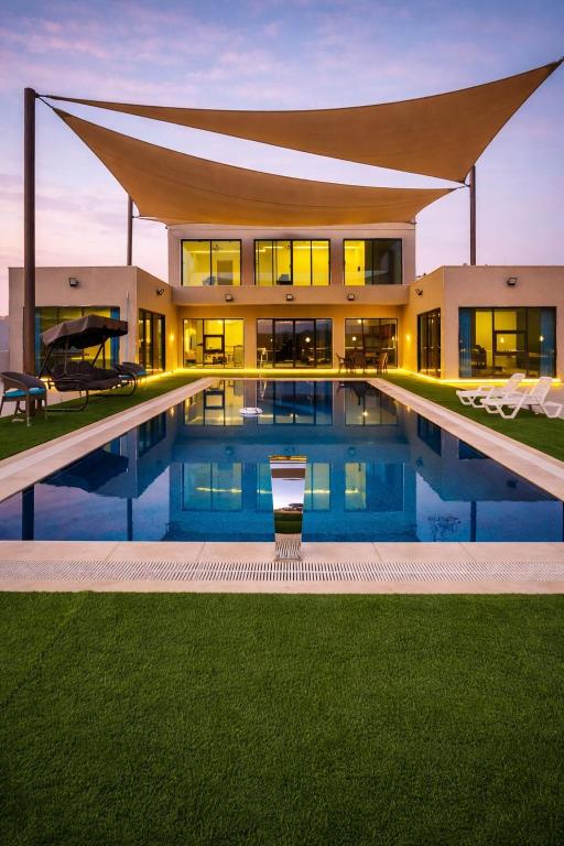 a large house with a swimming pool in front of it at Devon Chalet in Amman