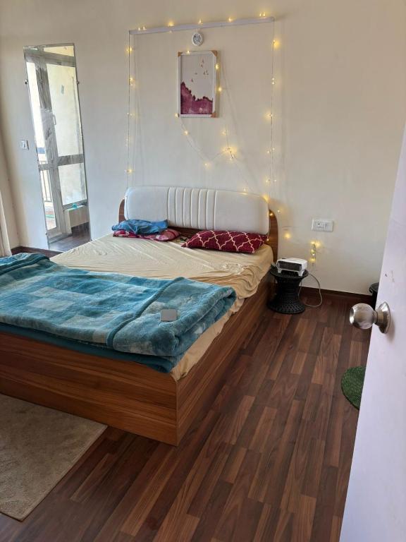 a bed in a room with a wooden floor at Express view homes in Noida
