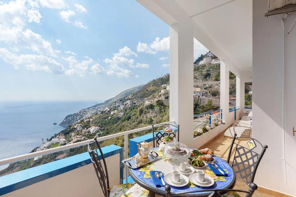 a balcony with a table with a view of the ocean at Le Terrazze Di Serafina in Furore