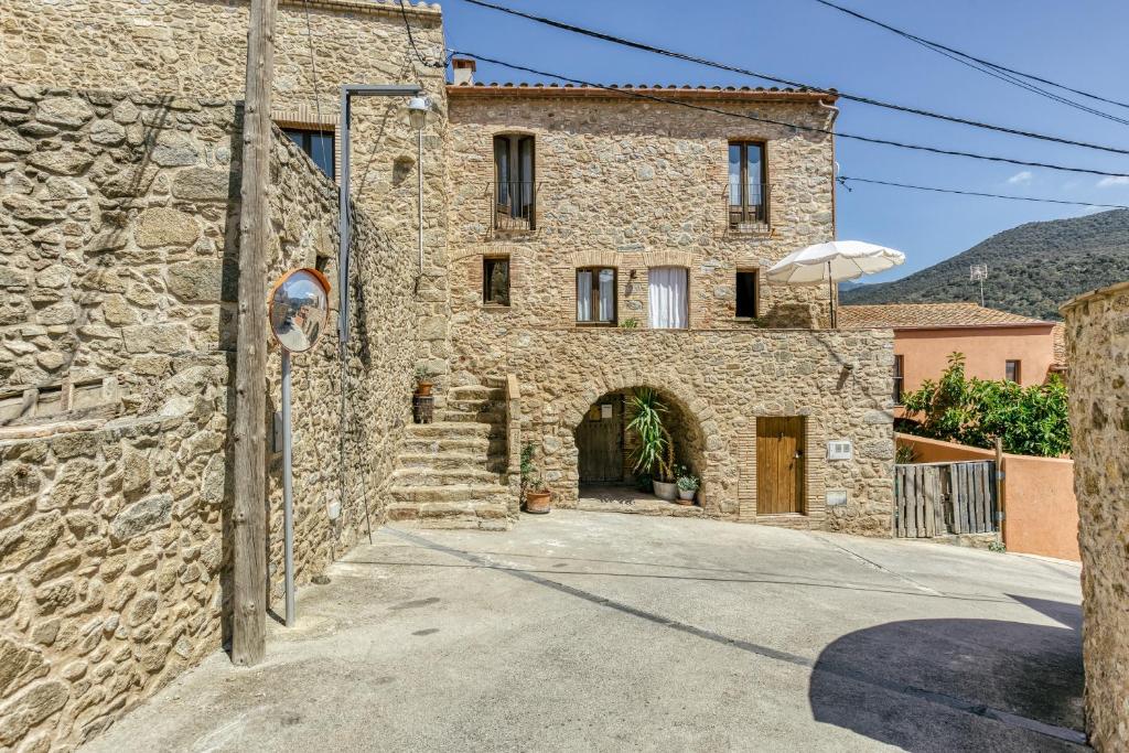 an external view of a stone house with a driveway at Casa de Pueblo in Cantallops