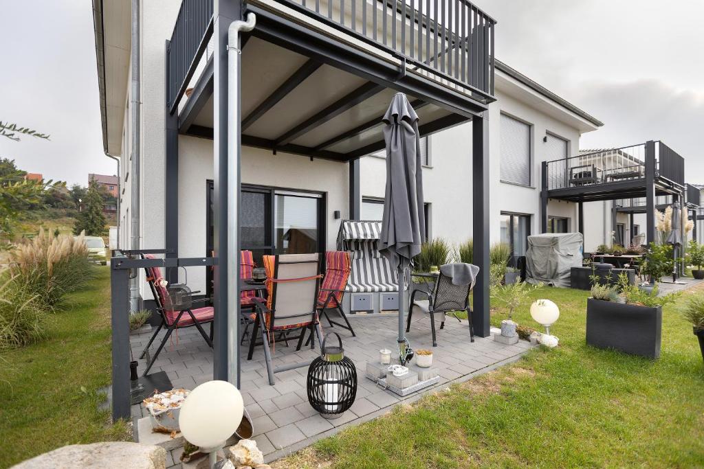 a patio with chairs and a table and an umbrella at Ferienwohnung 20b am Goitzsche See in Pouch