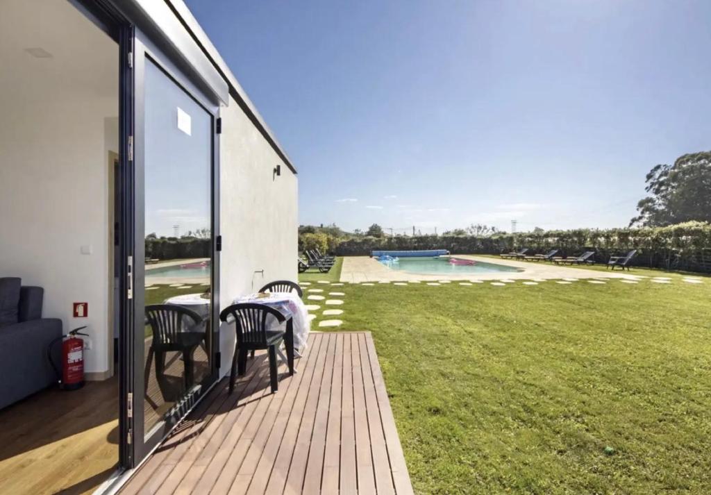 a patio with a table and chairs and a yard at Villa com 4 apartamentos in Apúlia