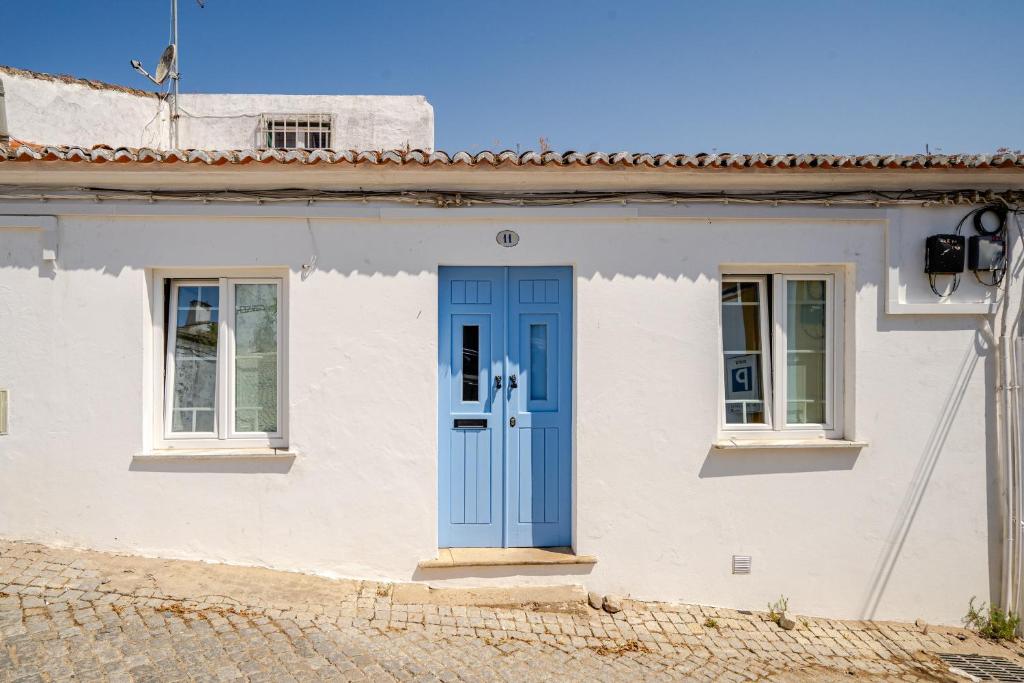 a white house with a blue door at Casa Do Castelo in Beja