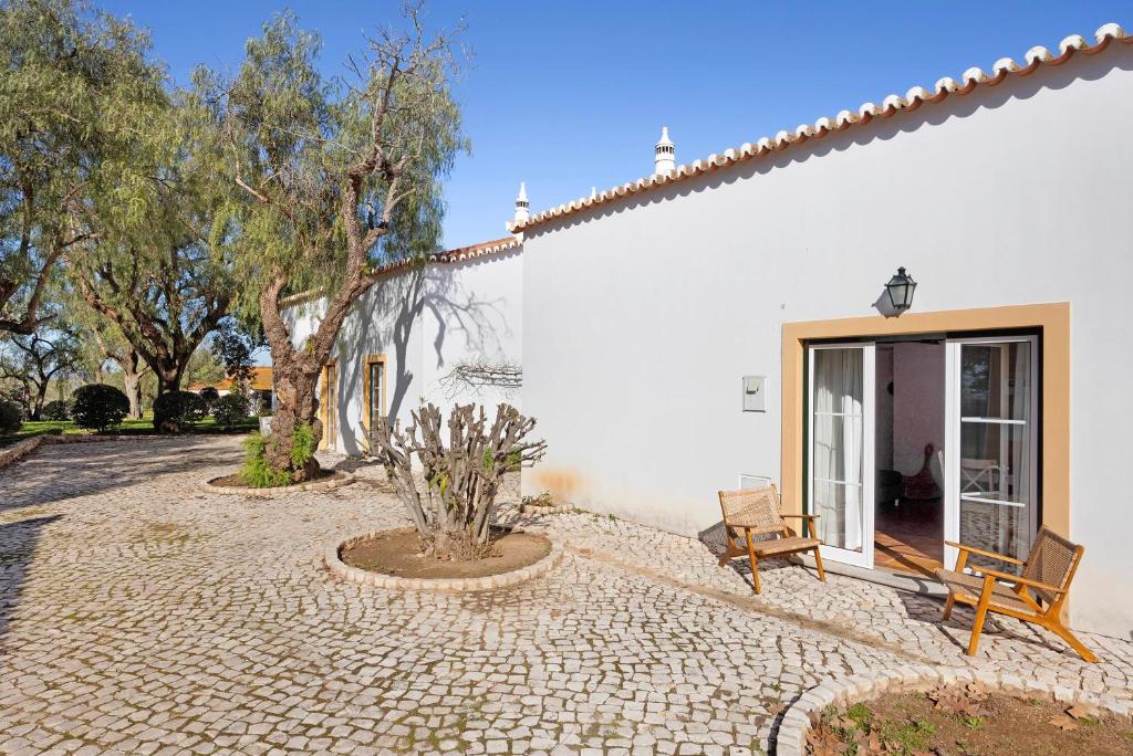 a white house with a bench and a window at Daniel Cottage - Portimão in Portimão