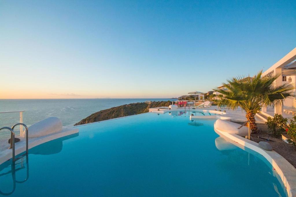 a large swimming pool with a view of the ocean at Kaladi Rock Avlemonas in Avlemonas