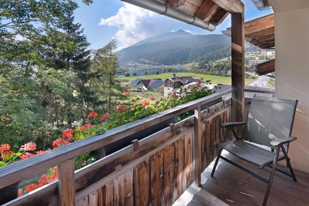a chair on a deck with a view of a mountain at Appartement Egart 1 in Resia