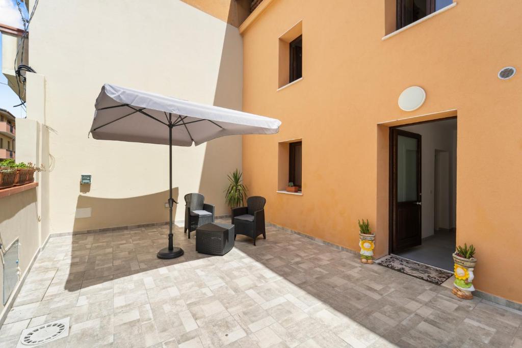 a patio with an umbrella next to a building at Villa Giovia in Guspini
