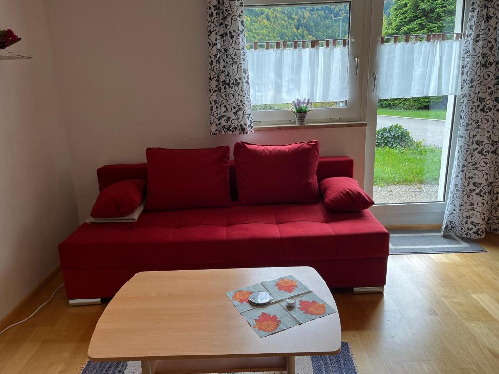 a red couch in a living room with a table at Haus Strohmeier in Brandenberg