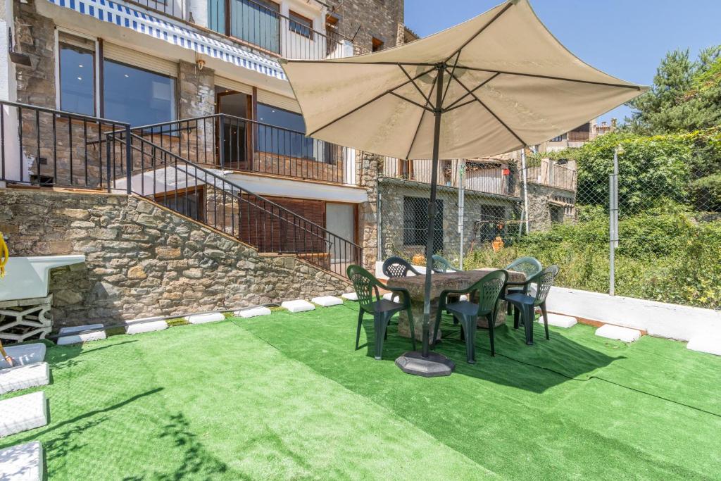 a patio with a table and chairs and an umbrella at Cal Confianza in Borredá
