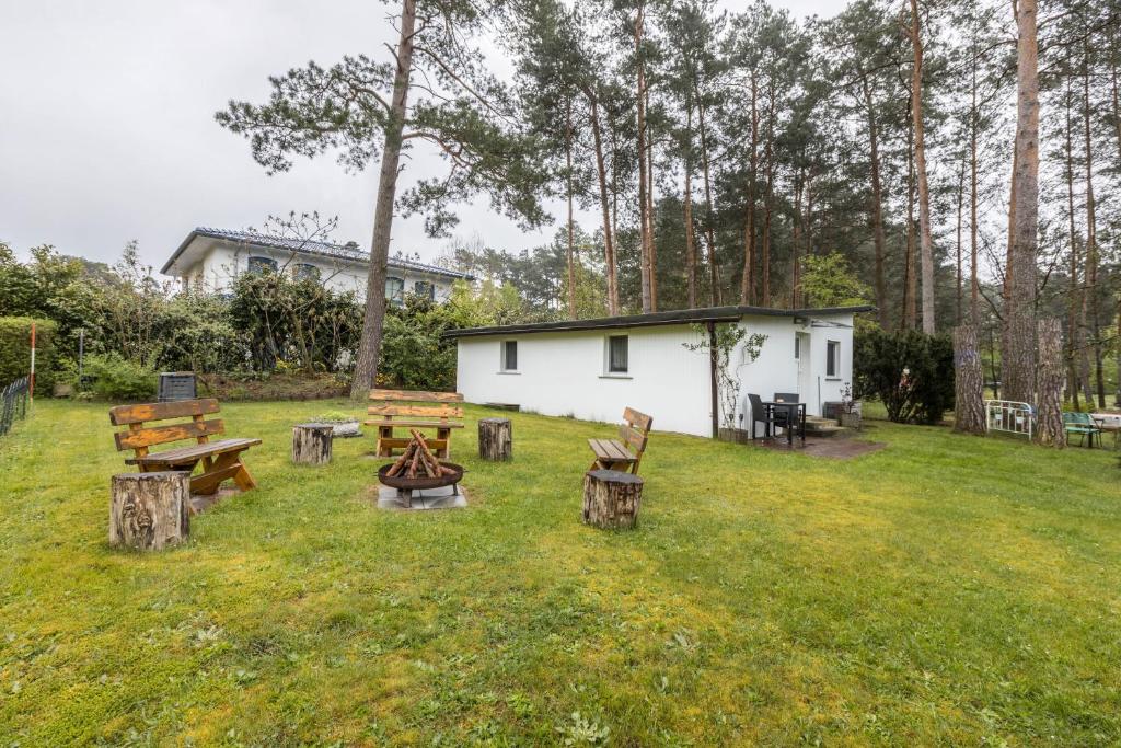 a group of picnic tables and benches in a yard at Ferienhäuschen Wils in Borkheide