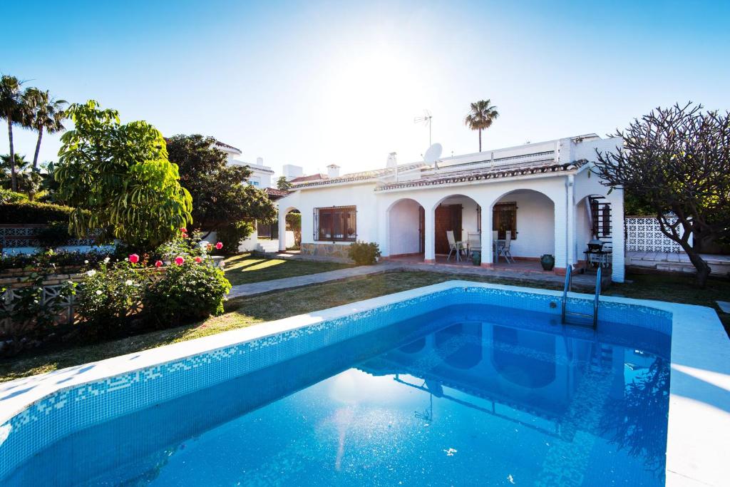 a swimming pool in front of a house at Best place Playamar in Torremolinos