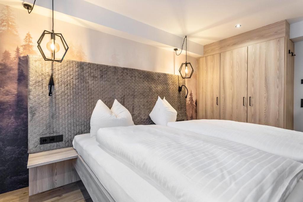 a bedroom with a white bed and two lights at Grauzone Grossarl App Nr 1 Cozy in Grossarl