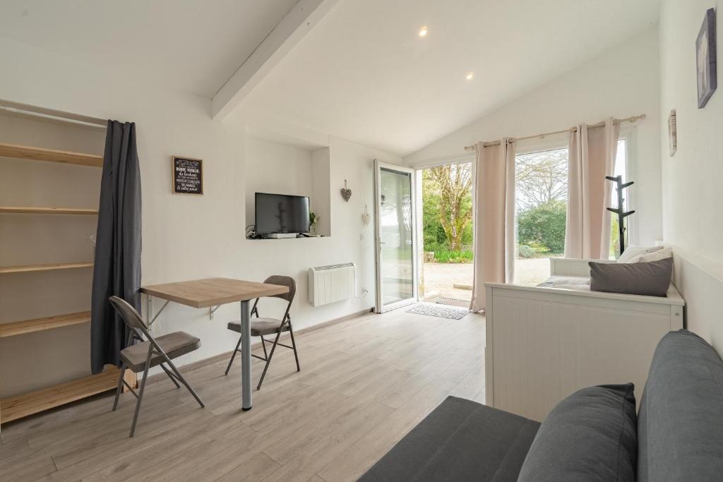 a living room with a table and a couch at Au petit chez nous in Cozes
