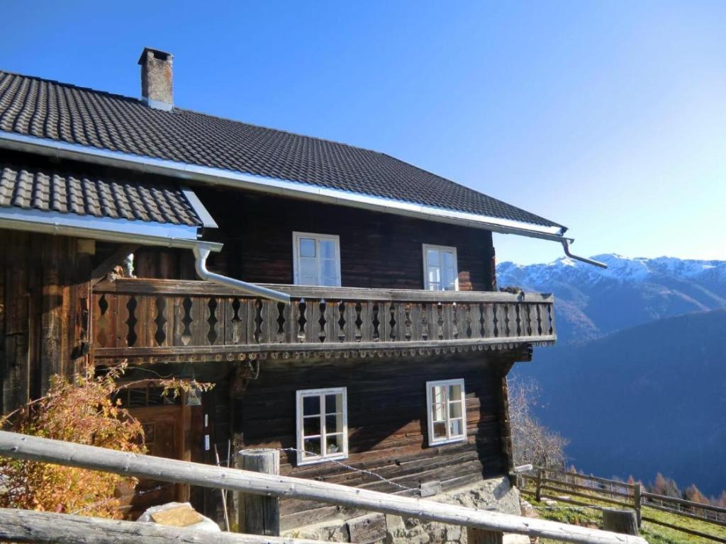 a wooden house with a balcony on a mountain at Adlerhütte in Stall