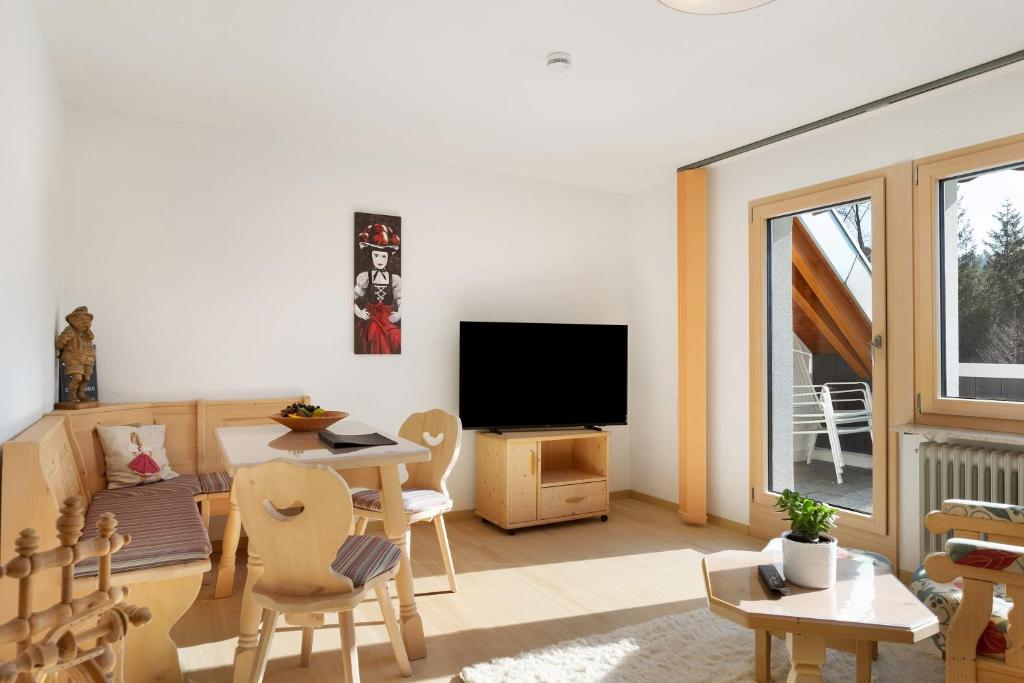 a living room with a table and a television at Fewo Kessler Schwarzwaldstüble in Häusern