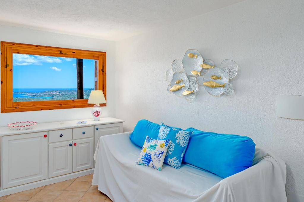 a living room with a blue couch and a window at Casa Ioana in Cugnana Verde